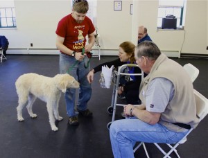 Mya approaches a patient with a walker.