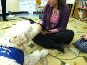 Teacher Paul Yolles models "reading-to-the-dog" and Violet models "listening" as the class looks on.